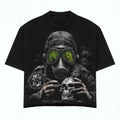 Black t-shirt with a graphic design of a person in a gas mask and skull, on a white background.